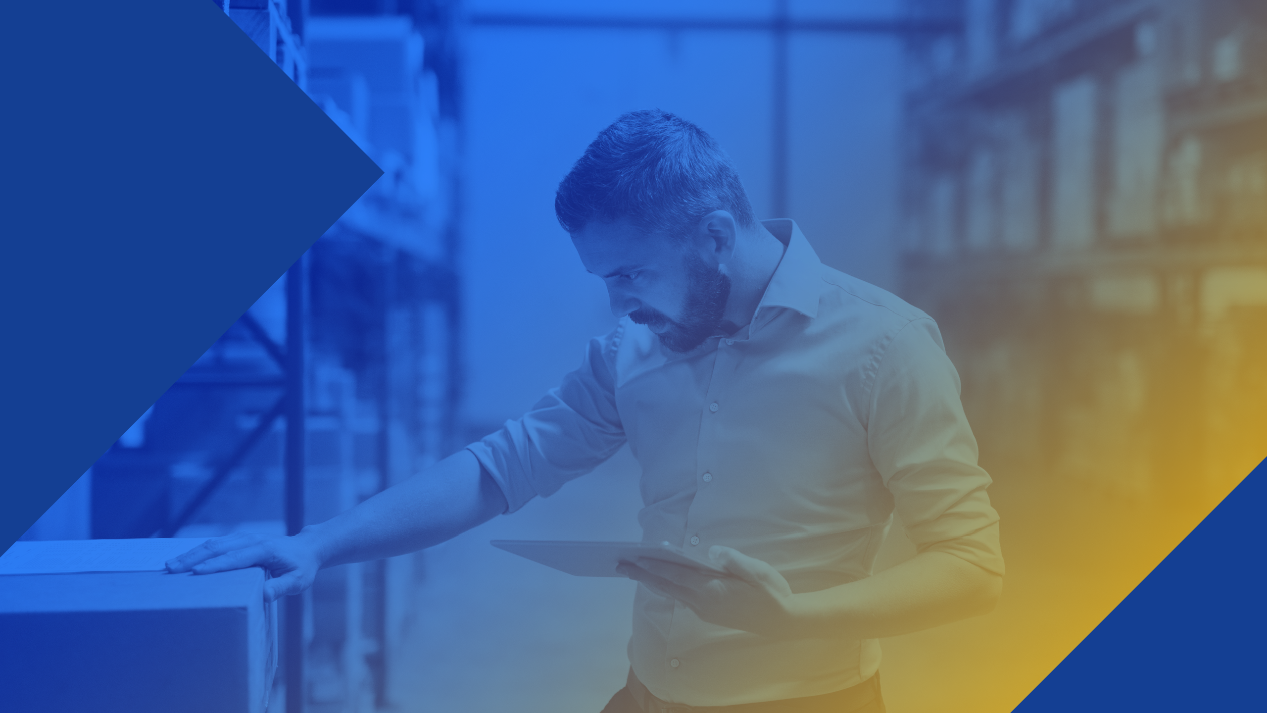 Man in a warehouse holding an ipad and checking the label on a cardboard box